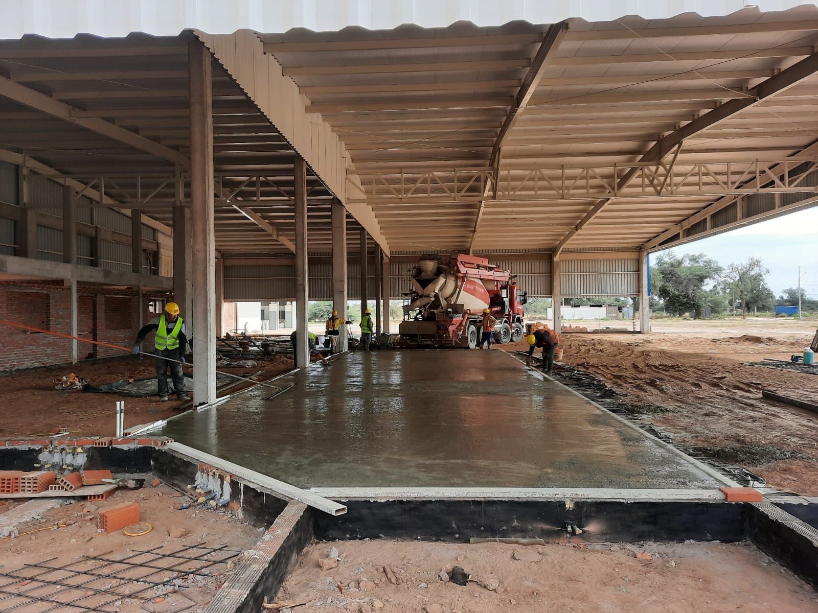 Piso de hormigon recien ejecutado con mixer rojo de HEC dentro de galpon